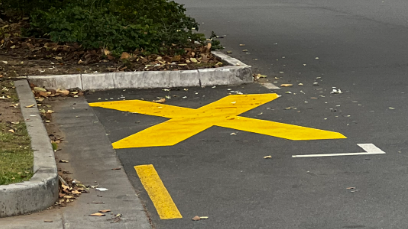 A large yellow X mark in the middle of a designated parking bay